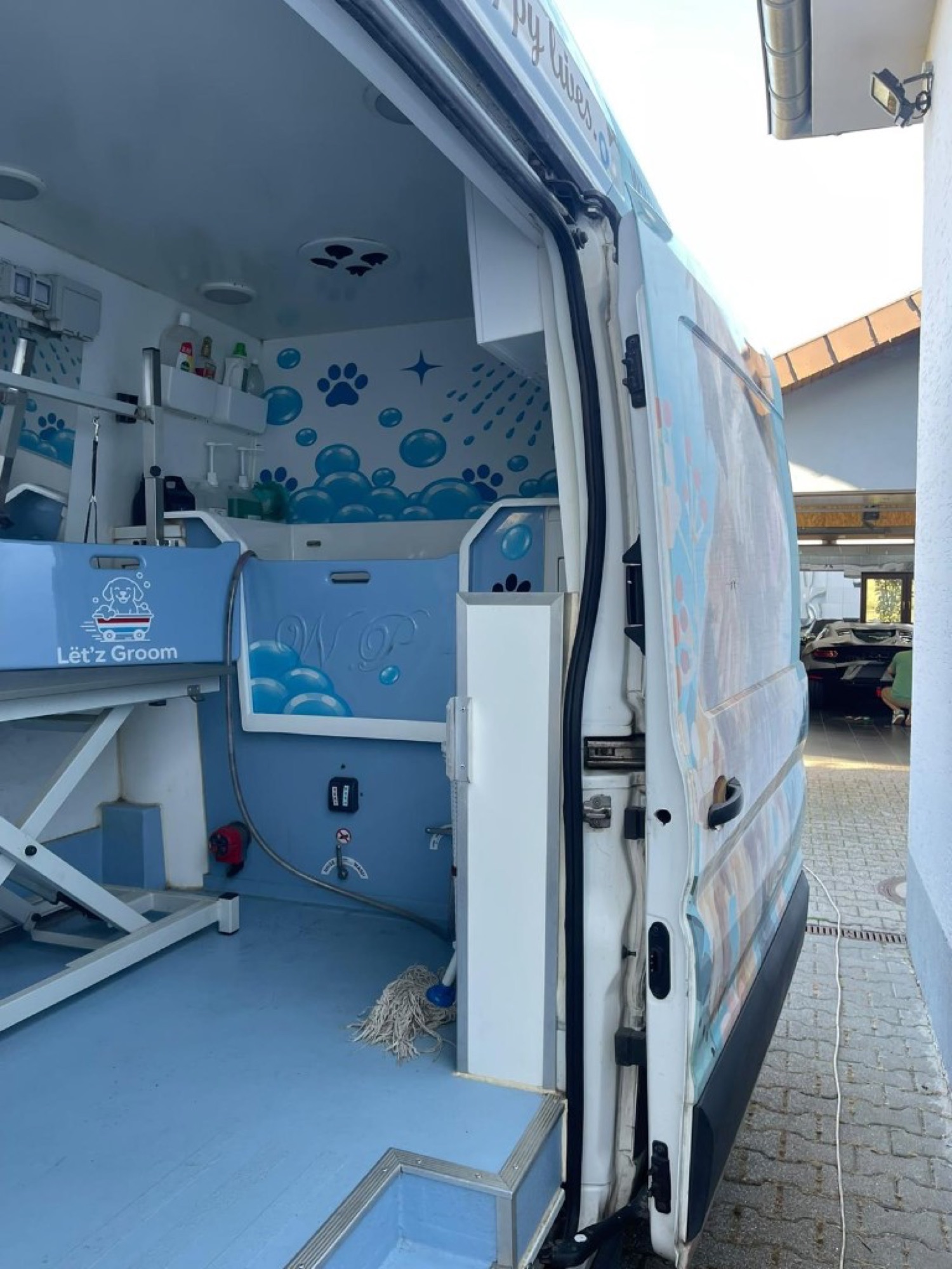 The mobile salon seen from the open door, with the bath and grooming table